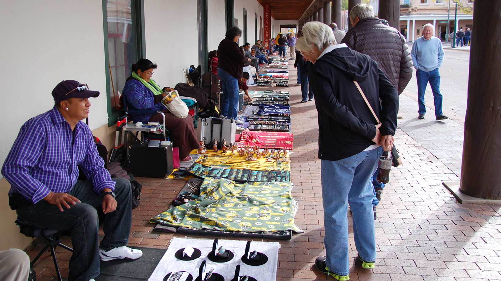 A portal artisan answers questions from a visitor about his handcrafted jewelry. Photo by Hannah Abelbeck